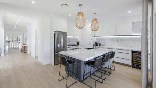 a kitchen with a table and chairs and a refrigerator at Tallowwood in Pokolbin