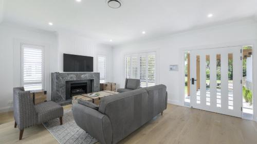 a living room with a couch and a fireplace at Tallowwood in Pokolbin