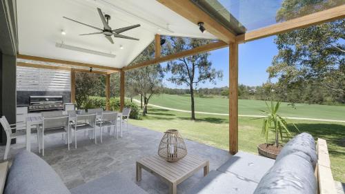 a screened in patio with a table and chairs at Tallowwood in Pokolbin