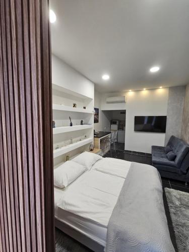 a bedroom with a bed and a couch and a television at Ellamar City Center Apartment in Makarska