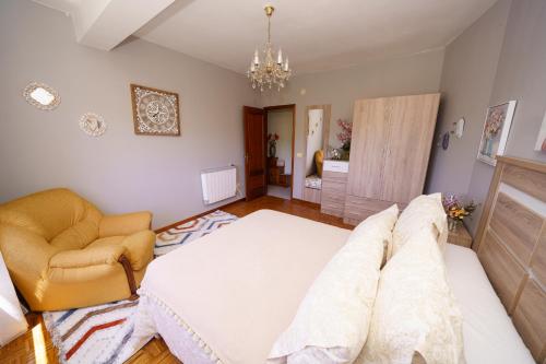 a living room with a large bed and a chair at Antoxos Sacra Home I in Chantada
