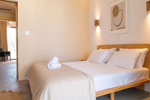 a bedroom with a bed with white sheets and pillows at Li Mango in Tigaki