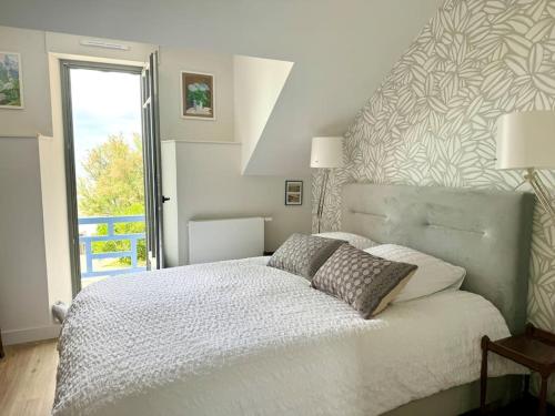 a bedroom with a white bed with two pillows at Face Mer Villa Le Ker Breton in Pornichet
