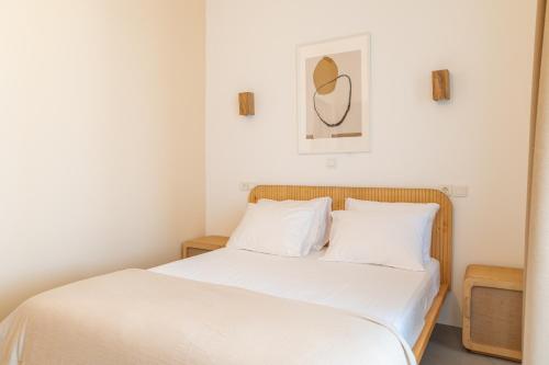 a bedroom with a bed with white sheets at Li Mango in Tigaki