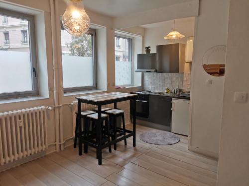 une cuisine avec une table et deux tabourets dans l'établissement Studio Cours Emile Zola Métro République, à Villeurbanne