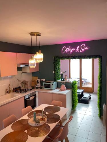 une cuisine et une salle à manger avec une table et des chaises dans l'établissement Maison Spacieuse Jacuzzi Wifi Netflix, à Quiévrechain