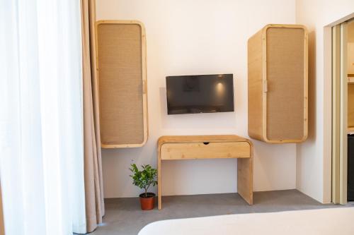 a room with a tv and a table with a desk at Li Mango in Tigaki