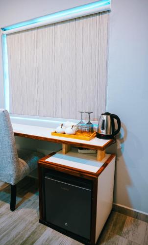 a desk with a microwave and a chair in a room at Serene Corner Nest in Gaborone