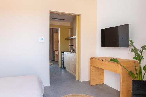 a living room with a tv on a wall at Li Mango in Tigaki