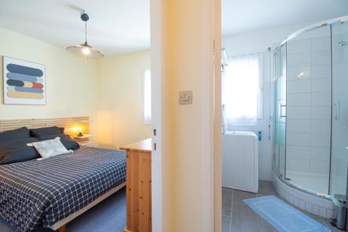 a bedroom with a bed and a bathroom with a shower at Le Franc bord I Plage à 200m in Crozon