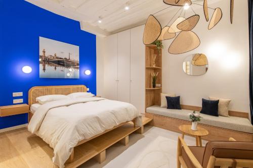 - une chambre avec un mur bleu et un lit dans l'établissement Geranimus : Heart of Paris Montorgeuil, à Paris