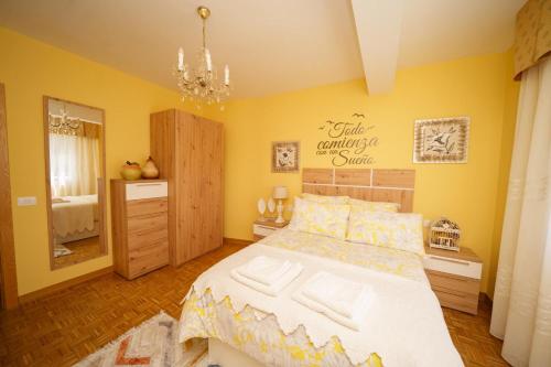 a bedroom with a large bed and a yellow wall at Antoxos Sacra Home II in Chantada