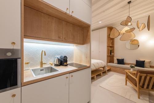une cuisine avec un évier et une chambre avec un lit dans l'établissement Geranimus : Heart of Paris Montorgeuil, à Paris