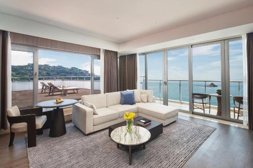 a living room with a couch and a table at Intercontinental Shenzhen Dameisha Resort by IHG in Shenzhen