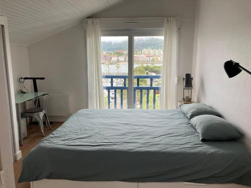 - une chambre avec un lit, une fenêtre et un bureau dans l'établissement Duplex Hendaye-plage, à Hendaye