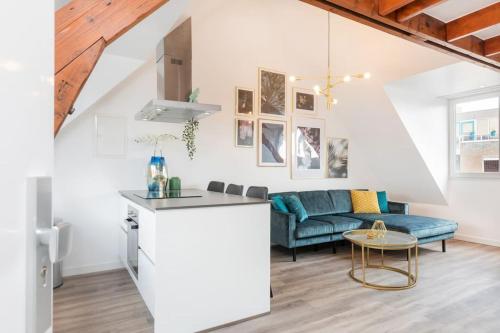 a kitchen and living room with a couch and a table at Eindhoven City Suites Hoogstraat E Modern 2P in Eindhoven