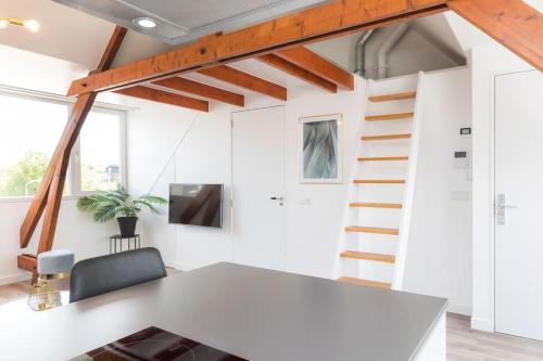 a room with a white table and a staircase at Eindhoven City Suites Hoogstraat E Modern 2P in Eindhoven