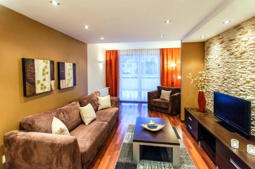 salon z kanapą i telewizorem w obiekcie Apartament Tit Aquarius Spa w Kołobrzegu