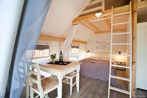 a room with a table and a bunk bed at Charming Slovenia - Herbal Glamping Resort Ljubno in Ljubno