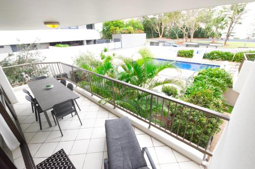 a balcony with a table and chairs and a pool at Seaview Resort in Mooloolaba