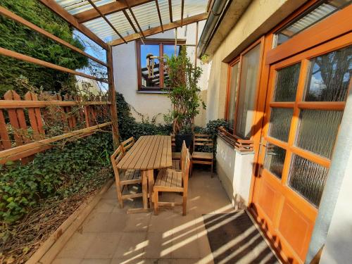 a patio with a wooden table and chairs on it at Ubytování Nad rybníkem Nová Říše - apartmán Východ in Nová Říše