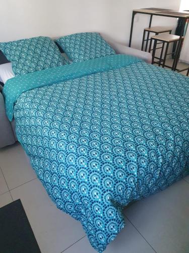 - un lit avec une couverture bleue dans l'établissement Appartement cosy et calme, à Nantes