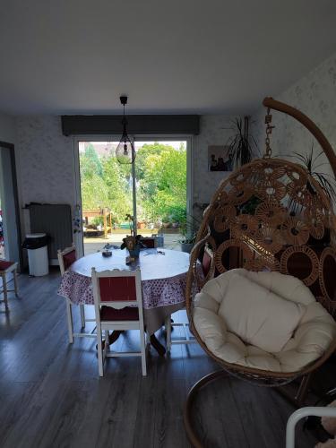 une salle à manger avec une table et des chaises et une fenêtre dans l'établissement Maison jardin calme, à Lambersart