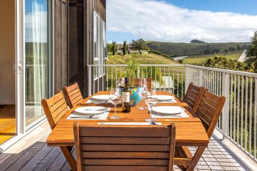 a wooden table on the balcony of a house at Vineyard Magic, Onetangi in Onetangi