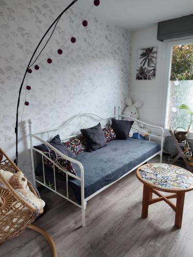 a bedroom with a bed with a blue couch at Maison jardin calme in Lambersart