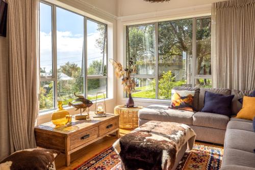 a living room with a couch and a large window at Vineyard Magic, Onetangi in Onetangi