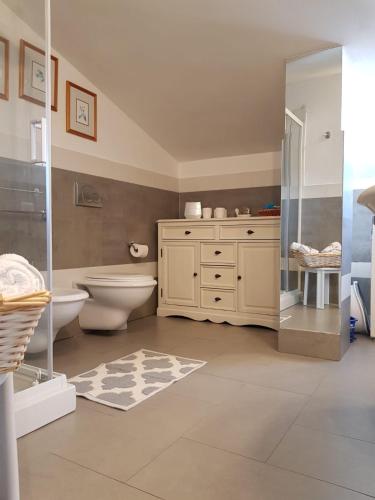 a bathroom with a toilet and a glass shower at Villa del Mar Country Loft in Sassari