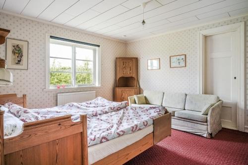 1 dormitorio con cama, sofá y ventana en Charming and rural cottage in Ockelbo, en Ockelbo