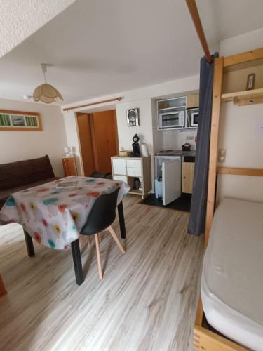 un salon avec une table et un lit dans l'établissement Studio classé 4 personnes face aux Thermes, avec coin nuit, à Le Mont-Dore