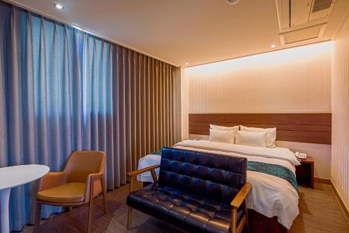 a hotel room with a bed and a chair and a table at Namsan Hill Hotel in Seoul