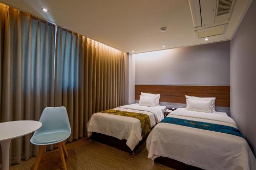 a hotel room with two beds and a table at Namsan Hill Hotel in Seoul