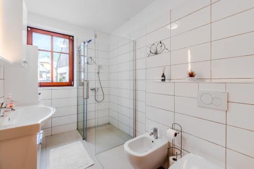 a white bathroom with a sink and a shower at Penzion Hosnar, hiša Mišc in Bovec