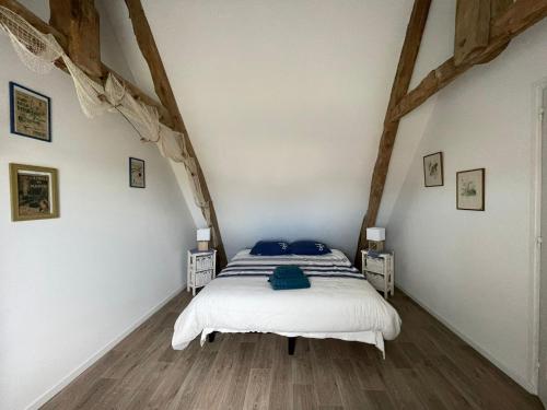 a bedroom with a bed with blue pillows on it at Nid de pie Grand duplex lumineux cadre verdoyant calme à 5 mn de la mer près Port en Bessin, Bayeux, Omaha Beach, in Commes