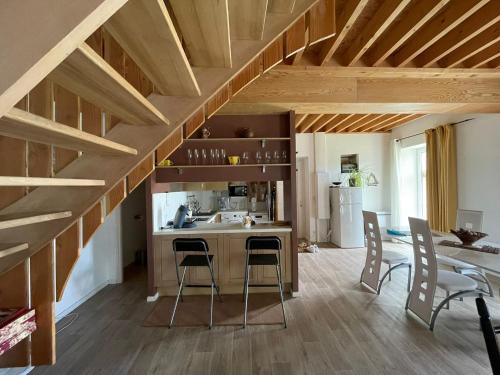 a kitchen with wooden ceilings and a table and chairs at Nid de pie Grand duplex lumineux cadre verdoyant calme à 5 mn de la mer près Port en Bessin, Bayeux, Omaha Beach, in Commes