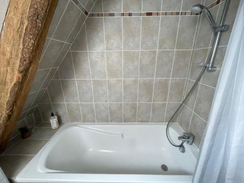 a white bath tub in a tiled bathroom at Nid de pie Grand duplex lumineux cadre verdoyant calme à 5 mn de la mer près Port en Bessin, Bayeux, Omaha Beach, in Commes