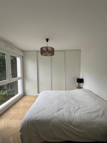 une chambre blanche avec un grand lit et une fenêtre dans l'établissement Brand new flat near Paris and public transports, à Le Perreux-Sur-Marne
