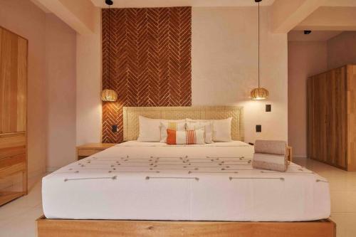 a bedroom with a large white bed in a room at Casa Boutique Peñasco Oaxaca in Oaxaca City