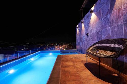 a swimming pool at night with a chair next to it at Casa Boutique Peñasco Oaxaca in Oaxaca City