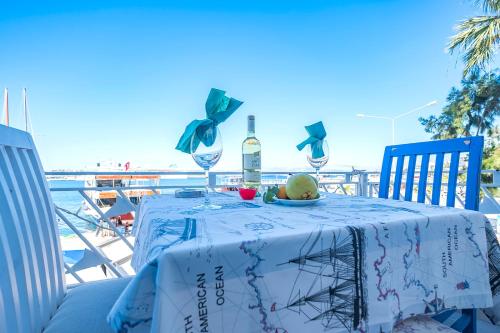 a table with a bottle of wine and some fruit on it at Villa Vongole in Cesme