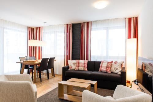 a living room with a couch and a table at Titlis Resort in Engelberg