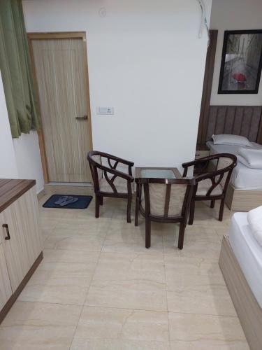 a living room with a table and chairs and a toilet at Hill side hotel in Karnaprayāg