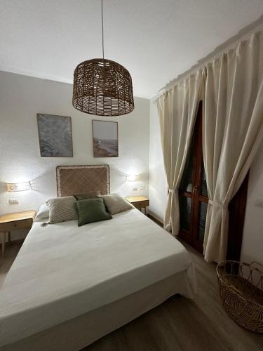 a bedroom with a large bed and a chandelier at Costa Rossa View Sunset in Cascabraga