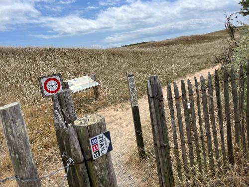 a fence with signs on it in a field at Villa les Tonnelles 1 à 800m de la plage et 500m de la forêt in Saint-Jean-de-Monts