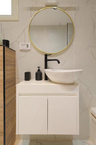 a bathroom with a white sink and a mirror at אחוזת דולב-הצימר in Bet Shemesh