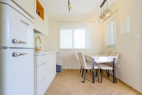 uma cozinha com uma mesa e cadeiras e um frigorífico em אחוזת דולב-הצימר em Bet Shemesh