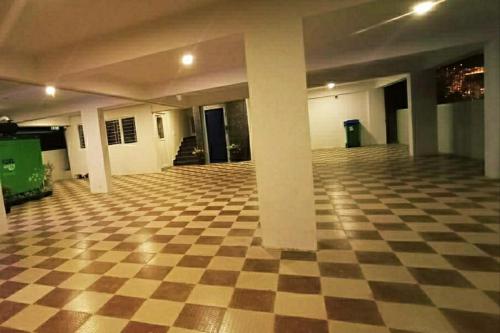 an empty room with a checkered floor and columns at Kavins inn in Kammasandra